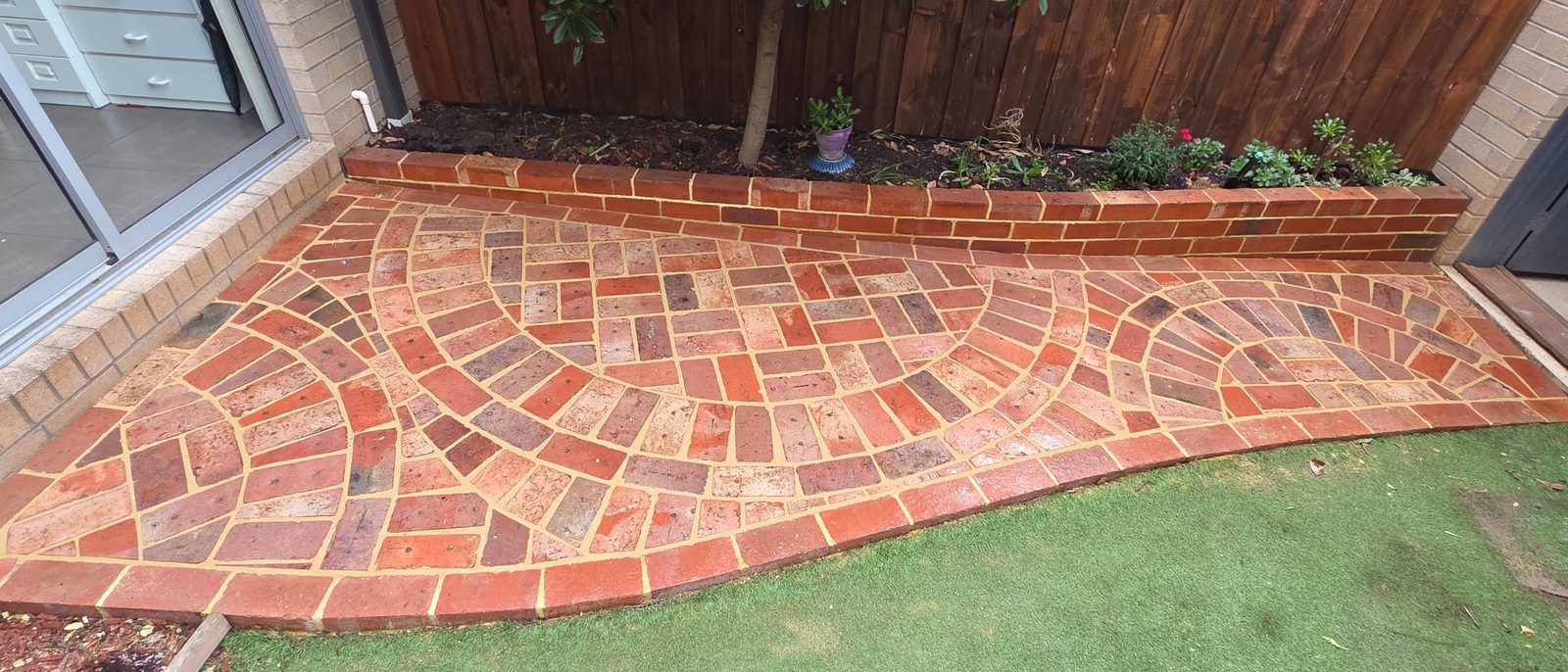 Curved brick paving with a brick garden wall